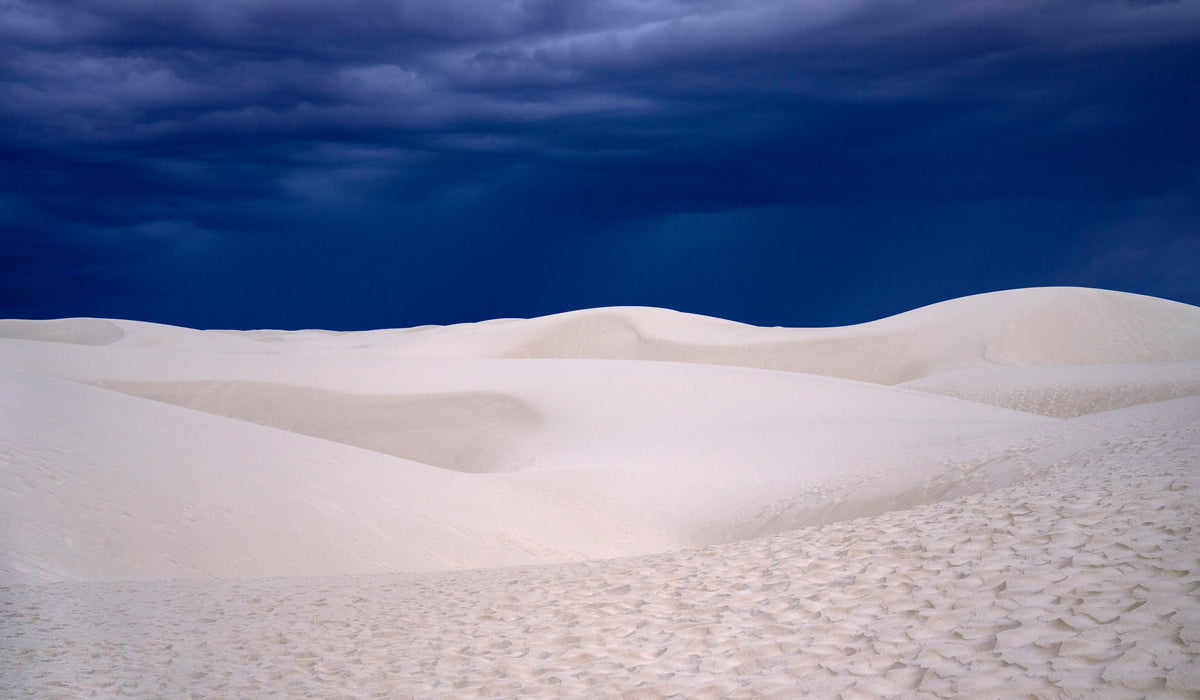 Dune Blue – fine art photograph of a deep indigo storm sky over the white dunes of White Sands National Park, New Mexico, by Aaron Chang