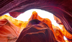 Shelter – fine art photograph looking up through an arch of orange and plum sandstone inside a slot canyon in northern Arizona, by Aaron Chang
