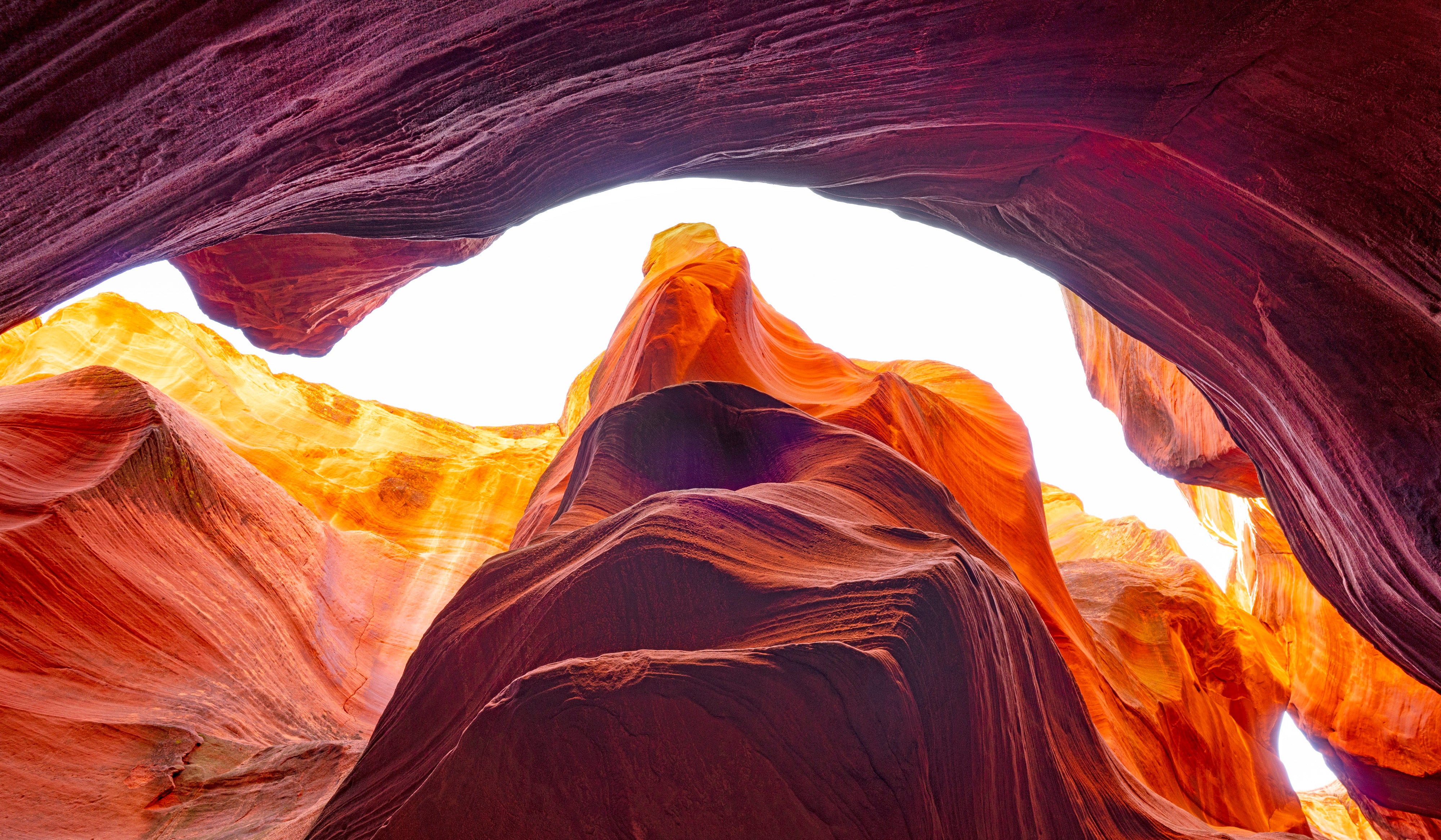 Shelter – fine art photograph looking up through an arch of orange and plum sandstone inside a slot canyon in northern Arizona, by Aaron Chang